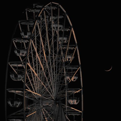 Grande roue de fête foraine illuminée la nuit avec un fin croissant de lune visible dans le ciel sombre.